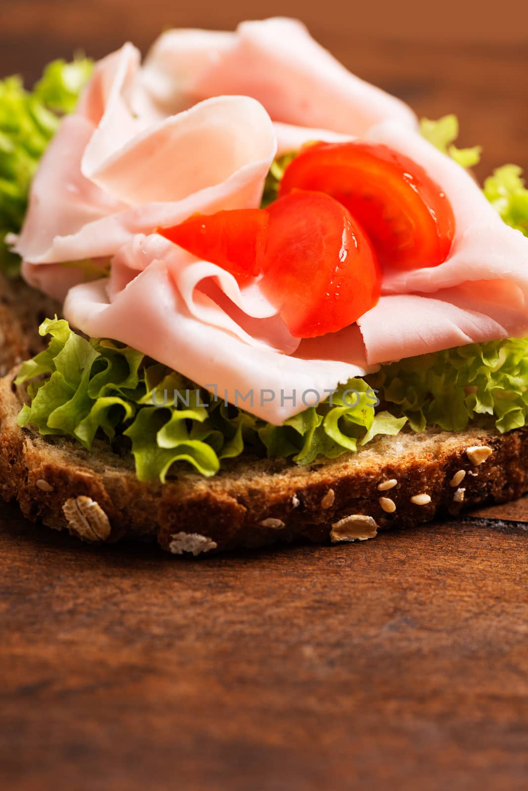 Ham sandwich composition with tomato on wooden table