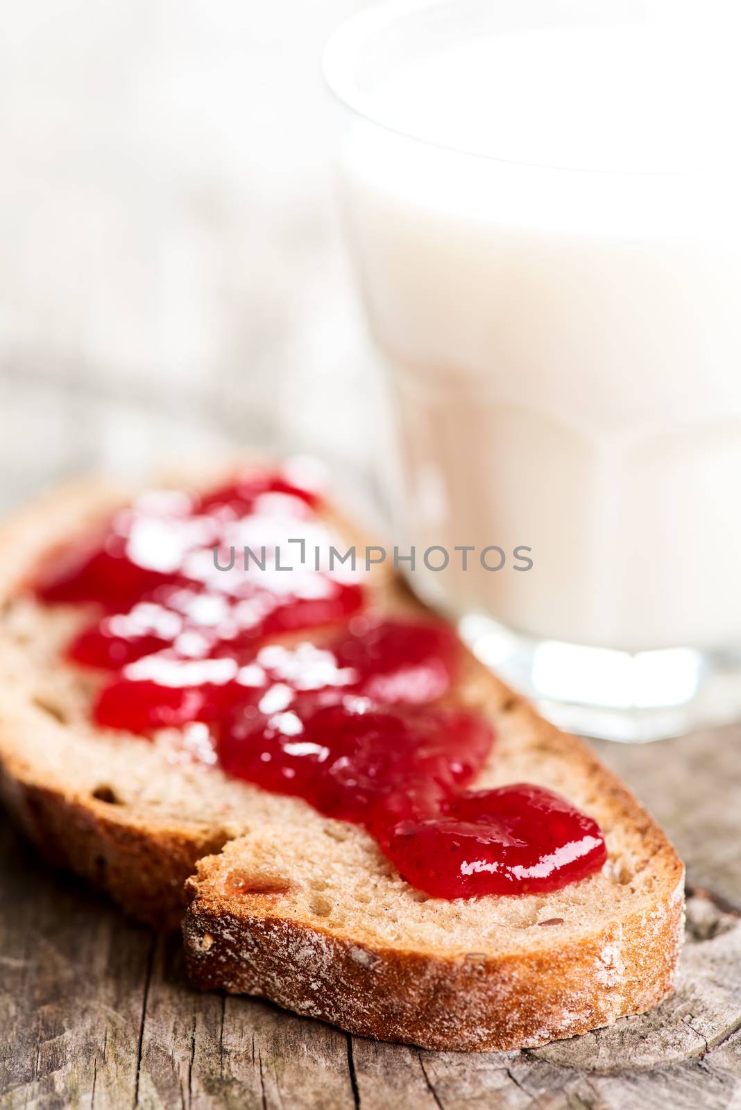 Bread with strawberry spread and glass of milk by Nanisimova
