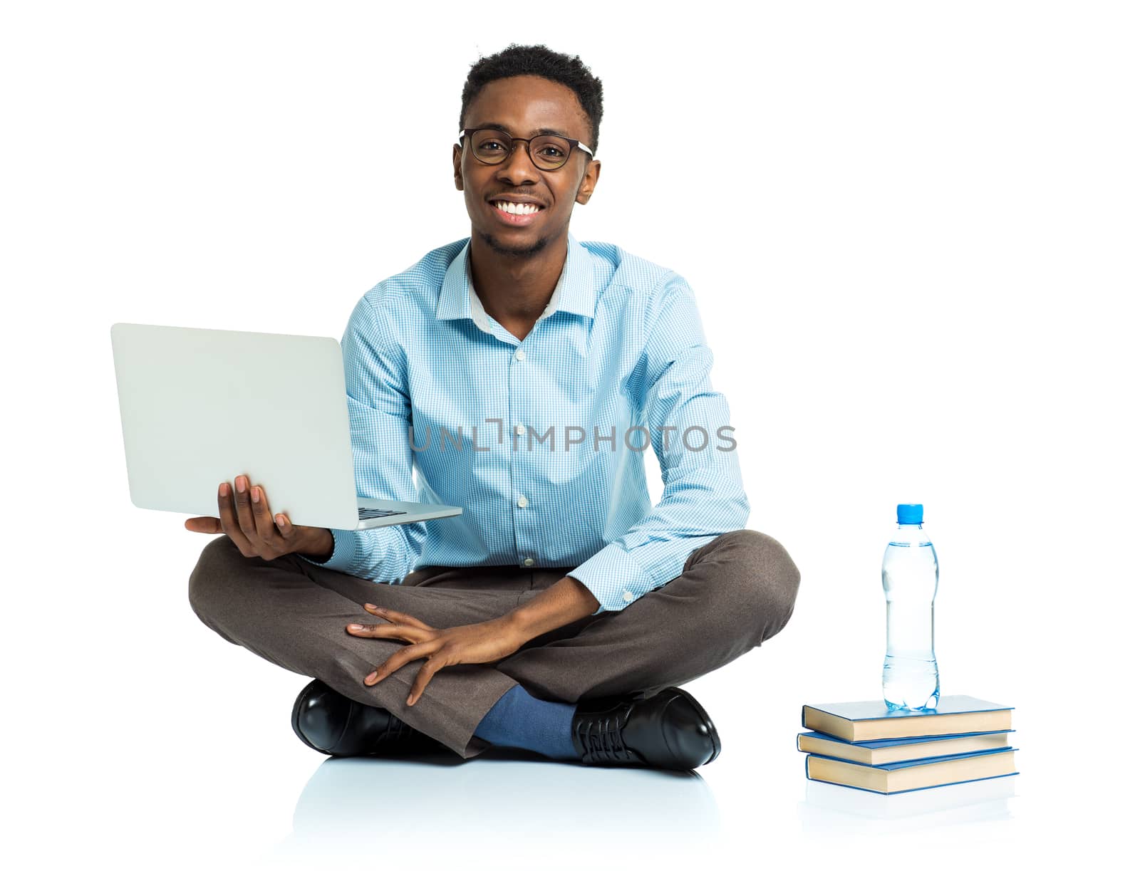 Happy african american college student sitting with laptop on wh by vlad_star