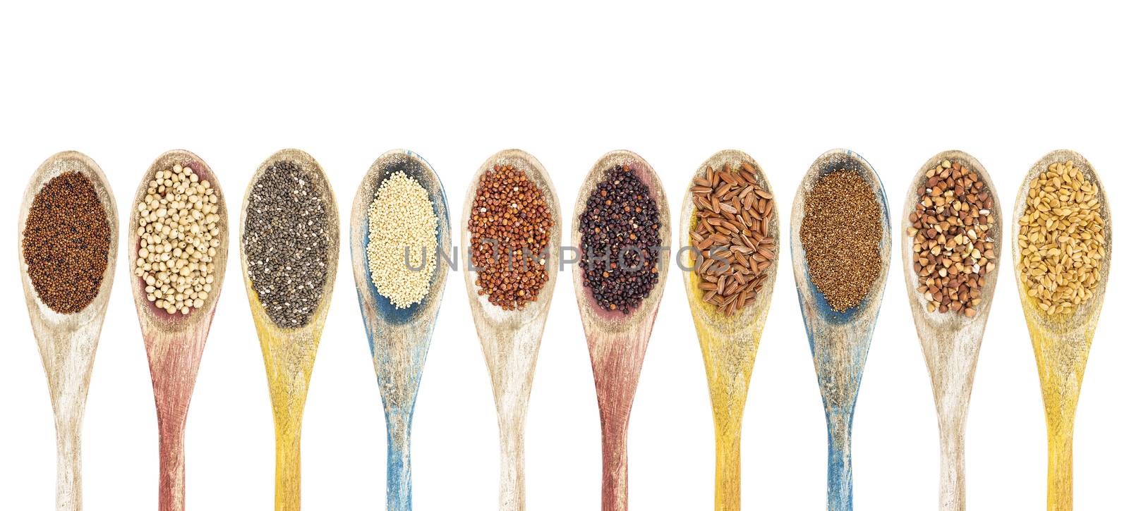 a collection of gluten free grains and seeds on isolated wooden spoons - kaniwa, sorghum, chia, amaranth,red quinoa, black quinoa, brown rice, teff, buckwheat, gold flax (from left to right)