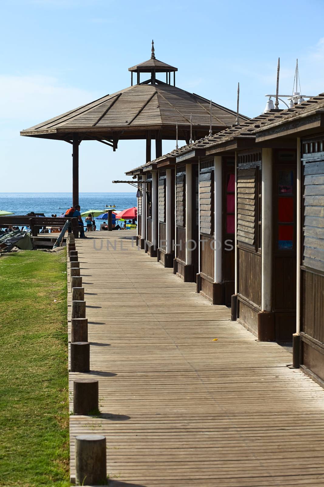 IQUIQUE, CHILE - JANUARY 23, 2015: Wooden sidewalk beside cabins leading to a wooden pavilion on Cavancha beach on January 23, 2015 in Iquique, Chile. Iquique is a free port city in Northern Chile.