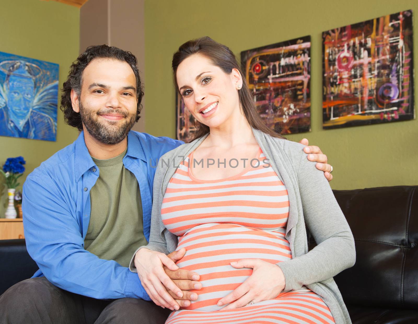 Handsome man with beautiful pregnant woman sitting together