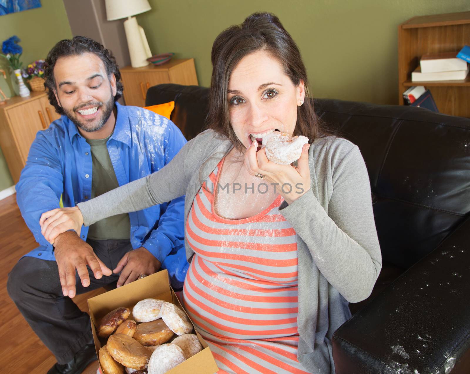 Greedy pregnant woman with hungry partner on sofa