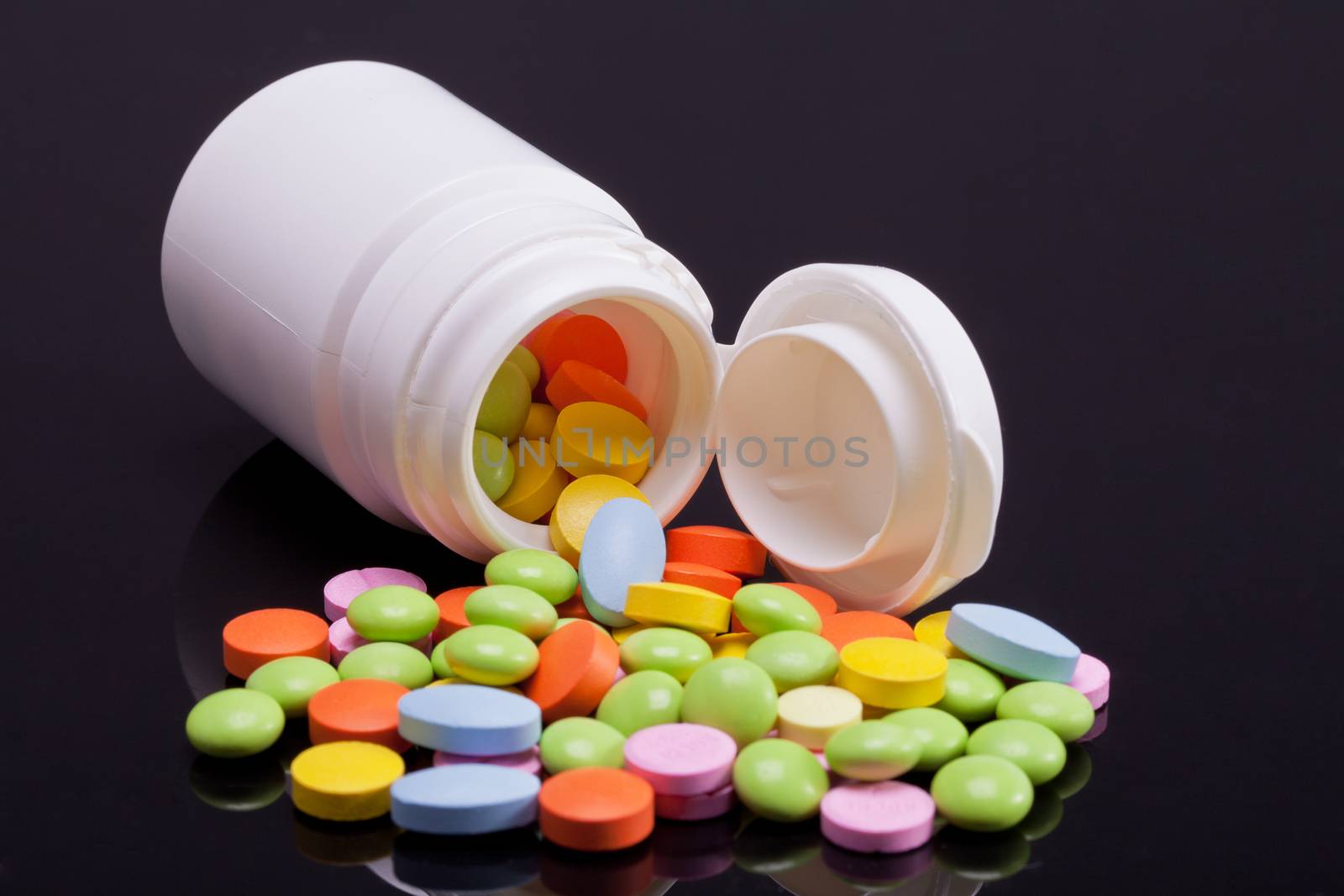 lot of colorful pills with white box on black background