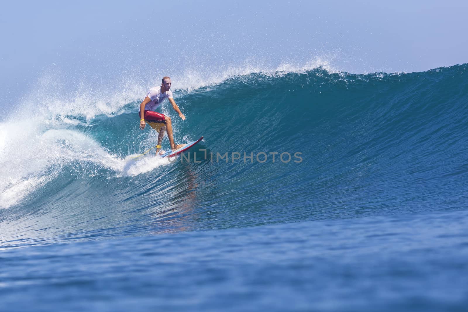 Surfer on Amazing Blue Wave, Bali island.