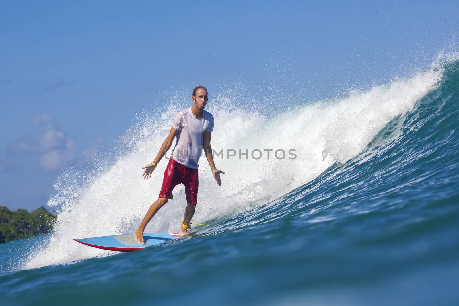 Surfer on Amazing Blue Wave, Bali island.