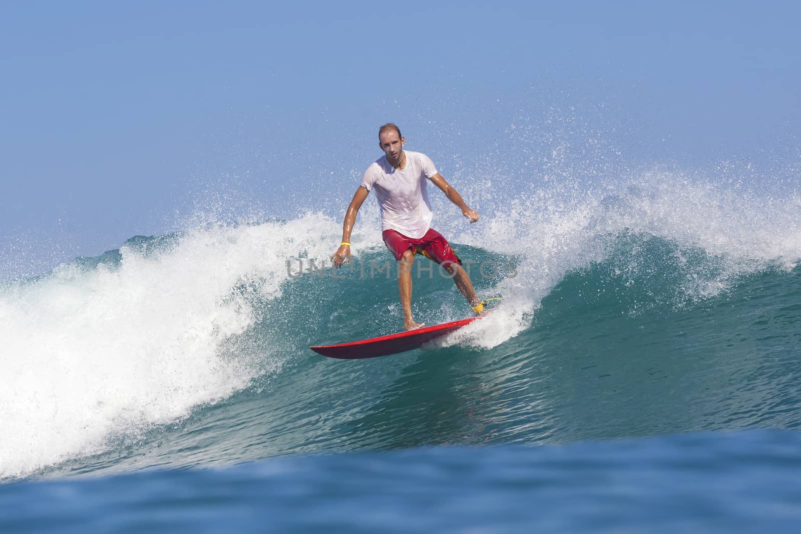 Surfer on Amazing Blue Wave, Bali island.