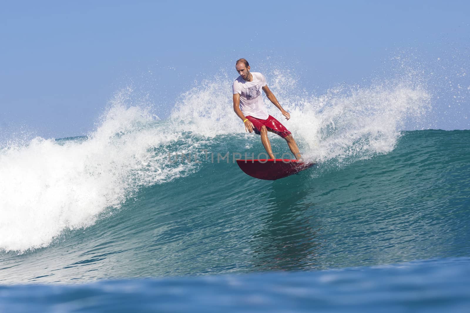 Surfer on Amazing Blue Wave, Bali island.