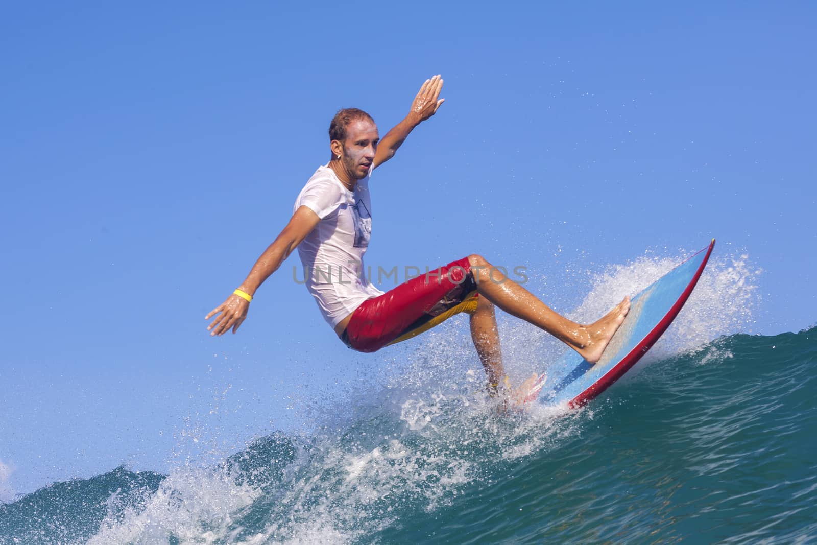 Surfer on Amazing Blue Wave, Bali island.