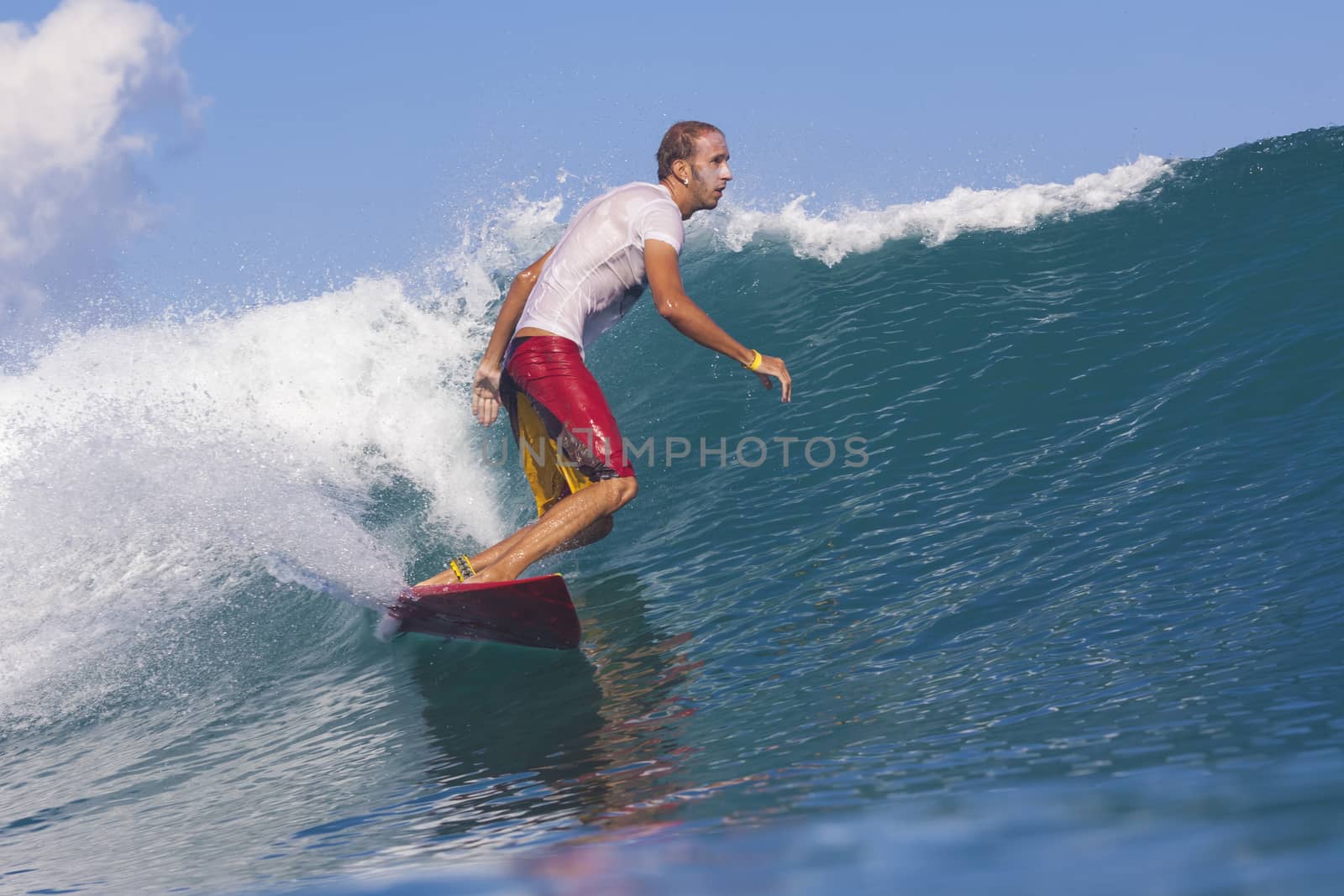 Surfer on Amazing Blue Wave, Bali island.