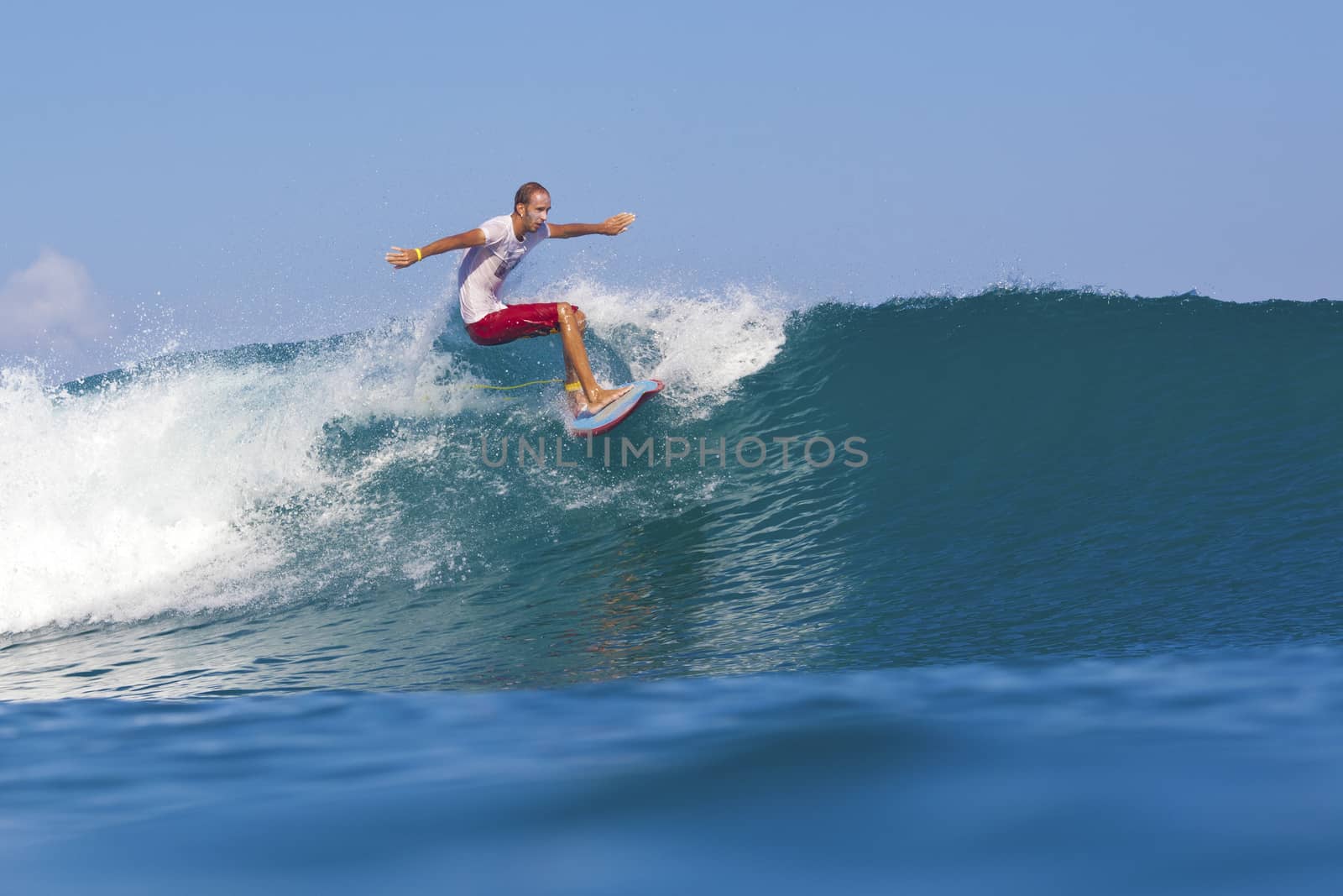 Surfer on Amazing Blue Wave, Bali island.