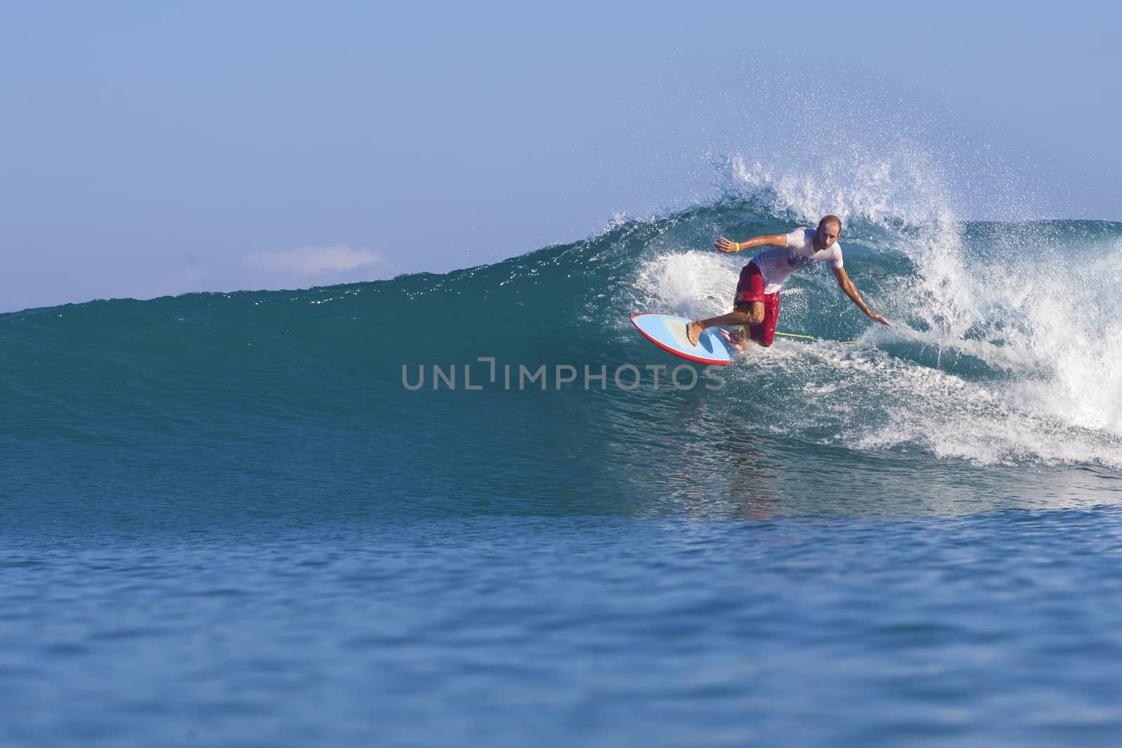 Surfer on Amazing Blue Wave, Bali island.