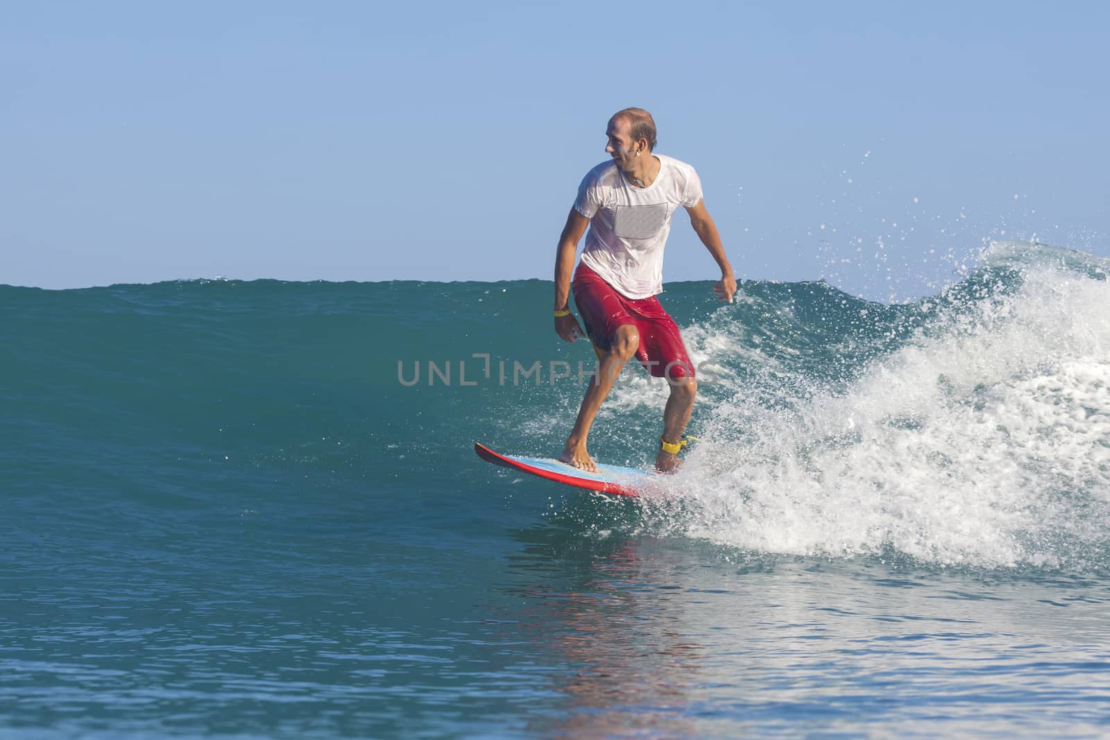 Surfer on Amazing Blue Wave, Bali island.