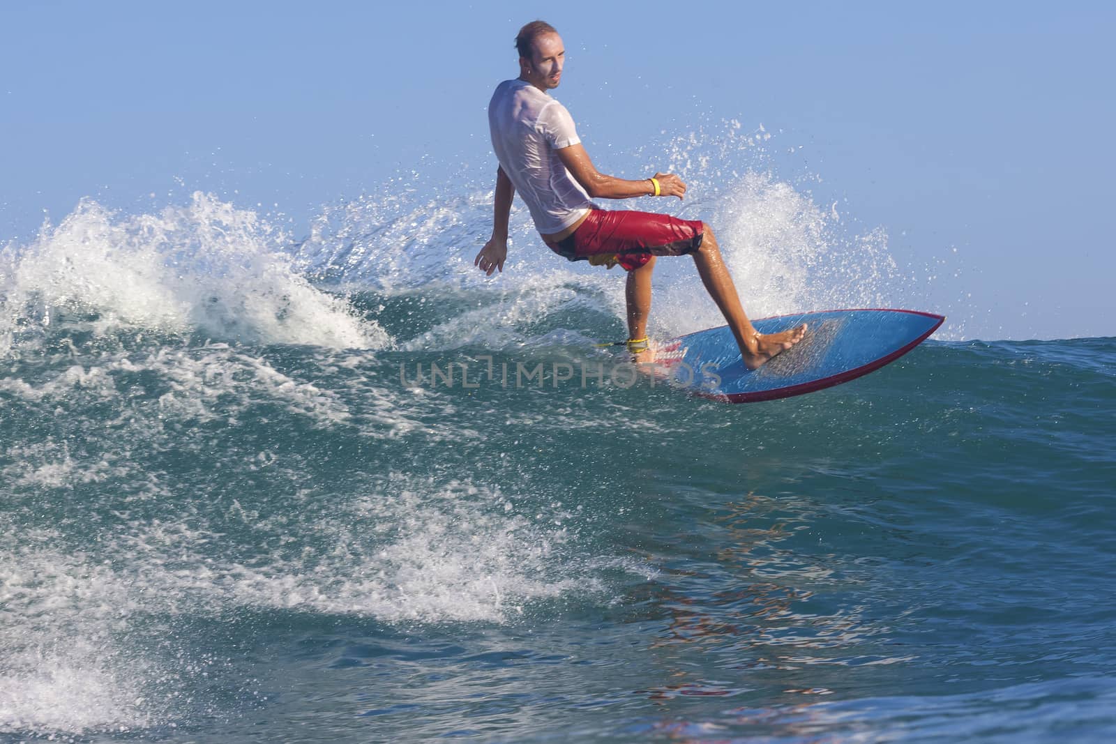 Surfer on Amazing Blue Wave, Bali island.