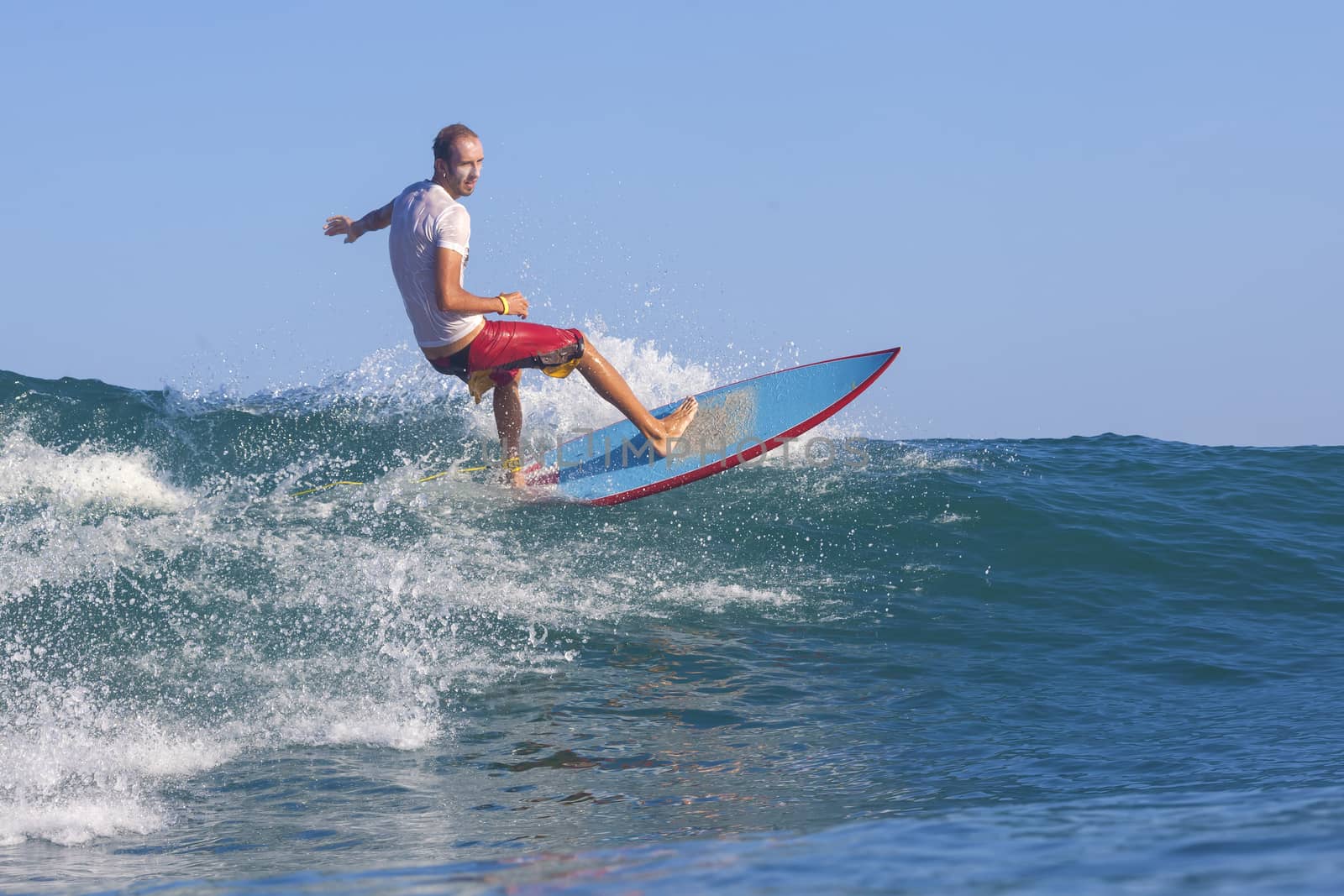 Surfer on Amazing Blue Wave, Bali island.