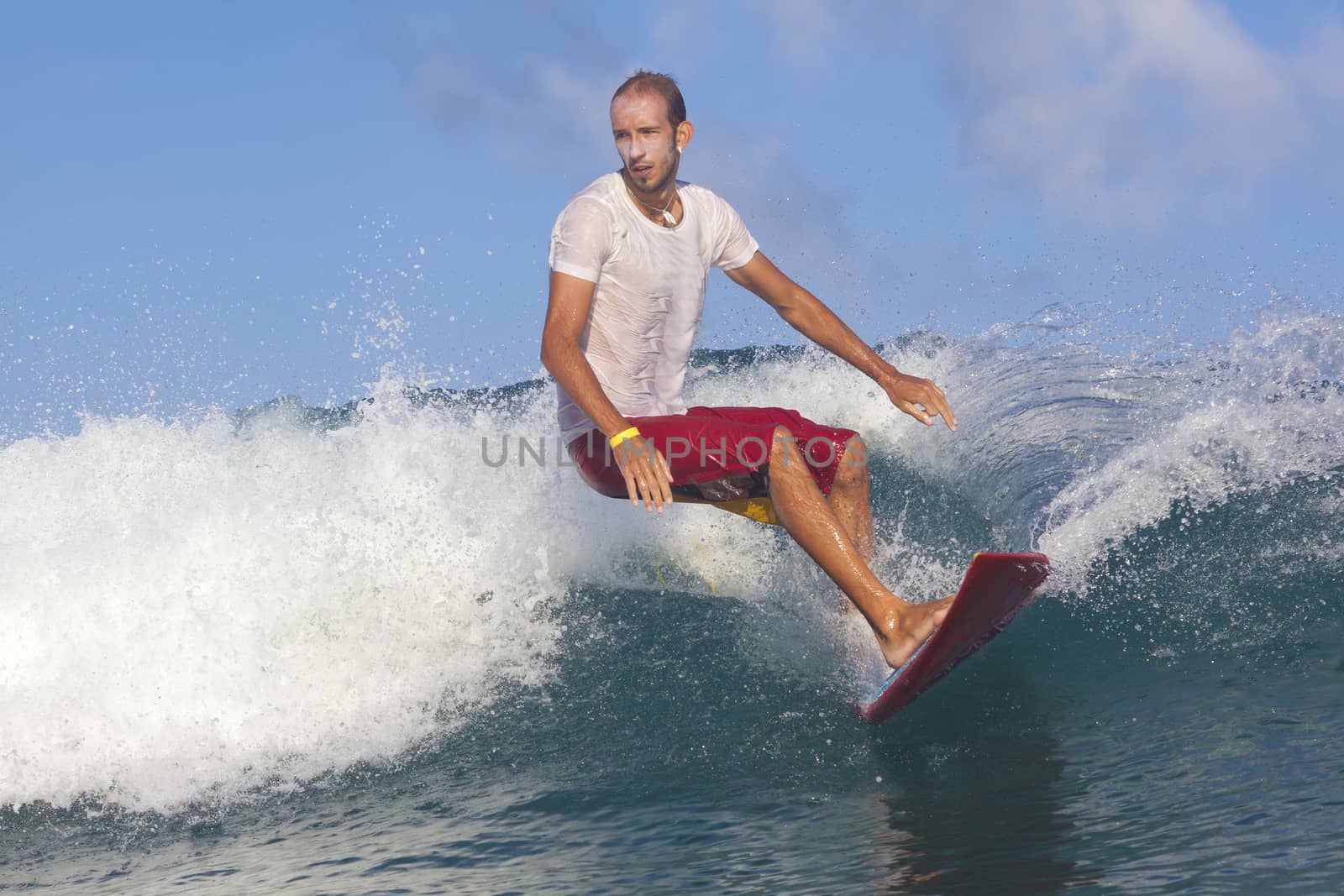 Surfer on Amazing Blue Wave, Bali island.