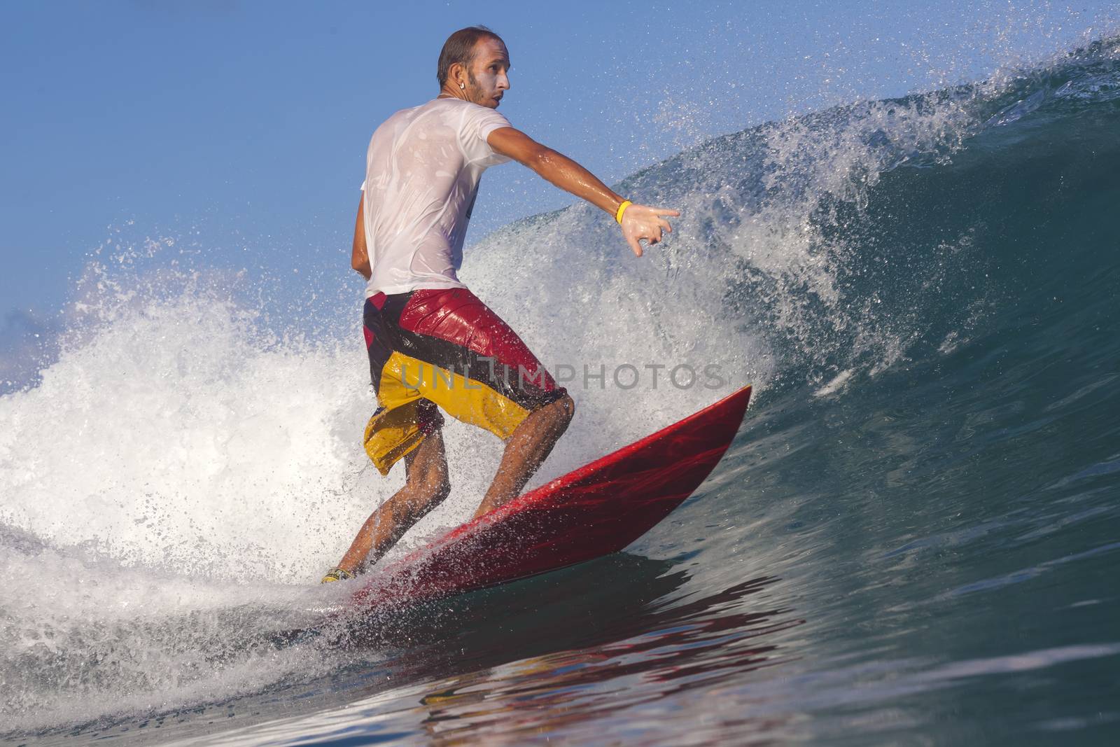 Surfer on Amazing Blue Wave, Bali island.