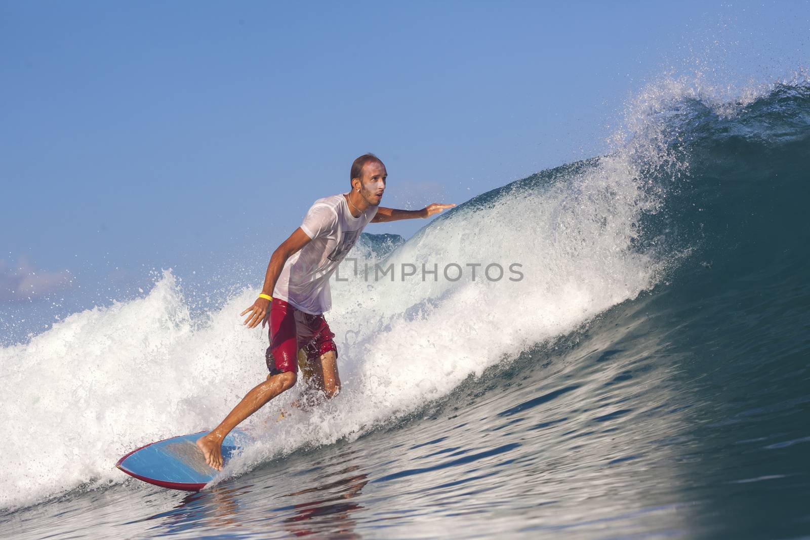 Surfer on Amazing Blue Wave, Bali island.