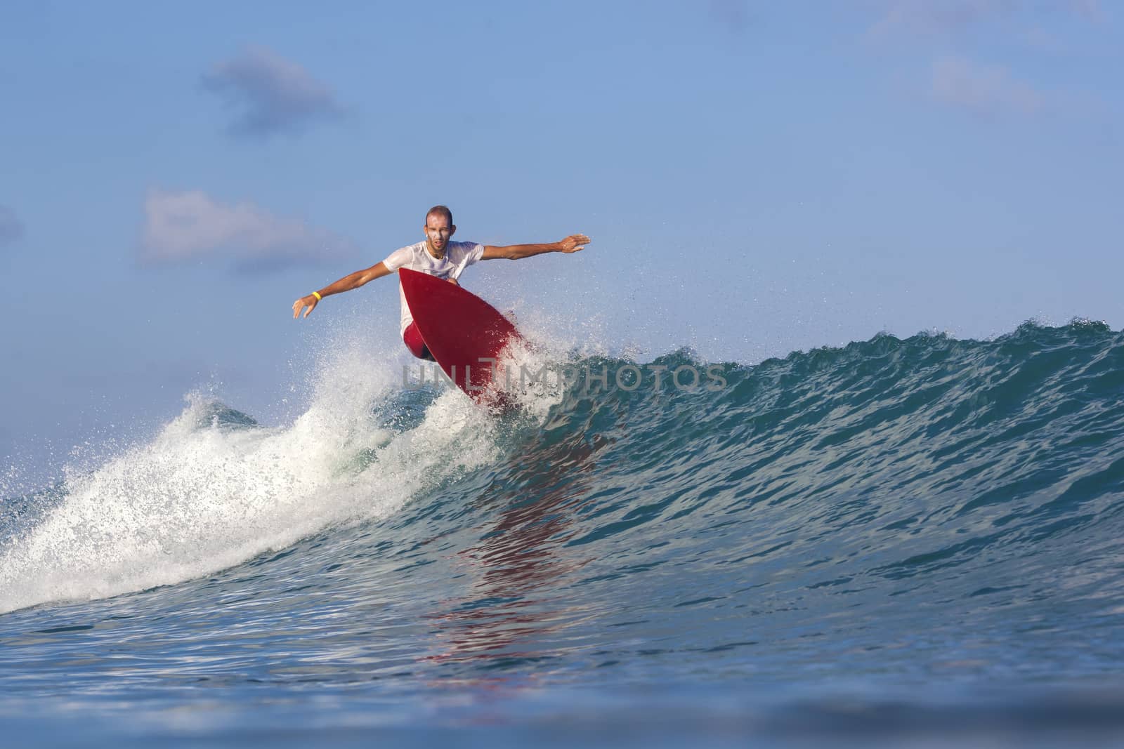 Surfer on Amazing Blue Wave, Bali island.