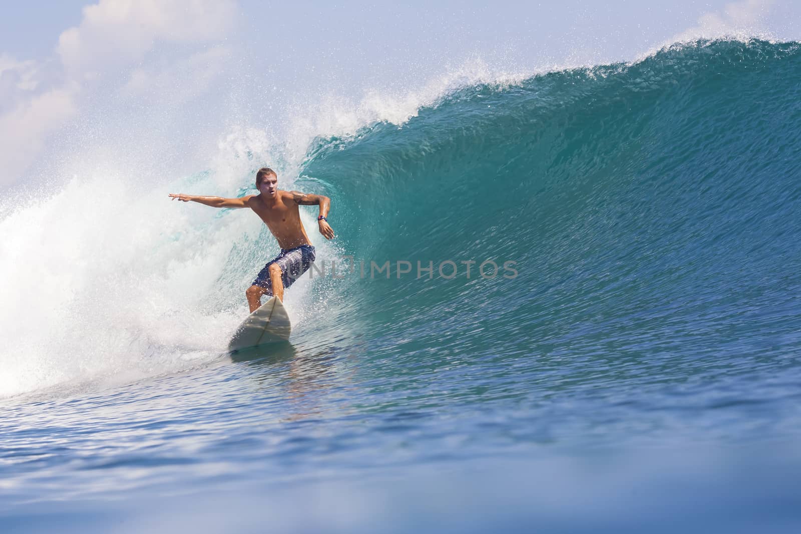 Surfer on Amazing Blue Wave, Bali island.