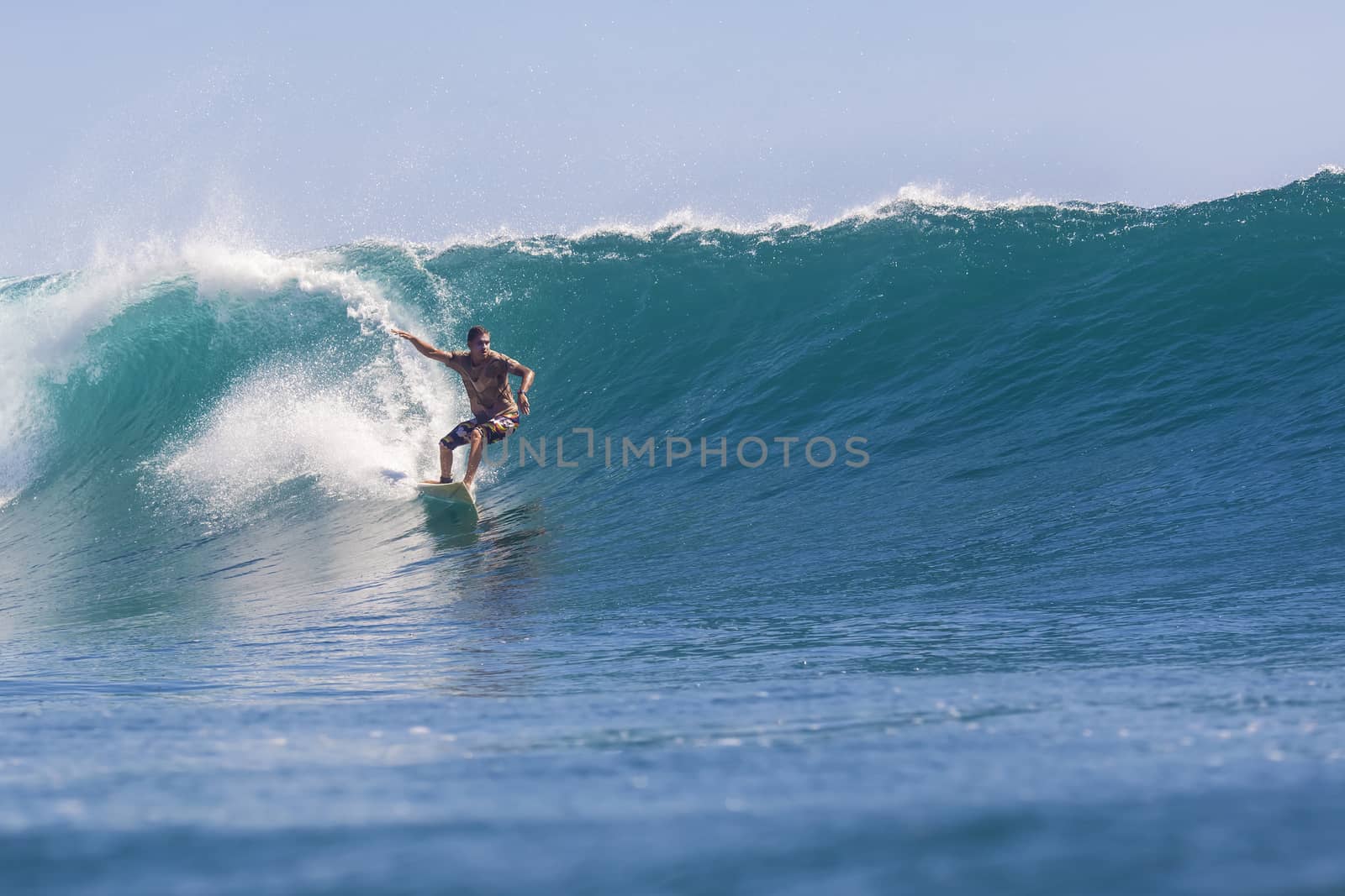 Surfer on Amazing Blue Wave, Bali island.