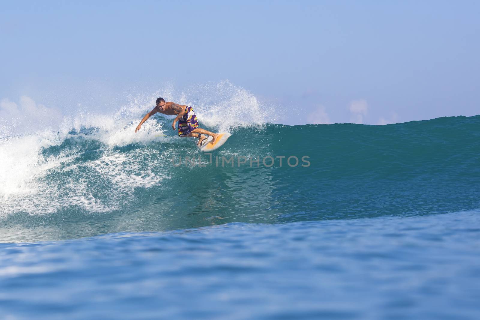 Surfer on Amazing Blue Wave, Bali island.