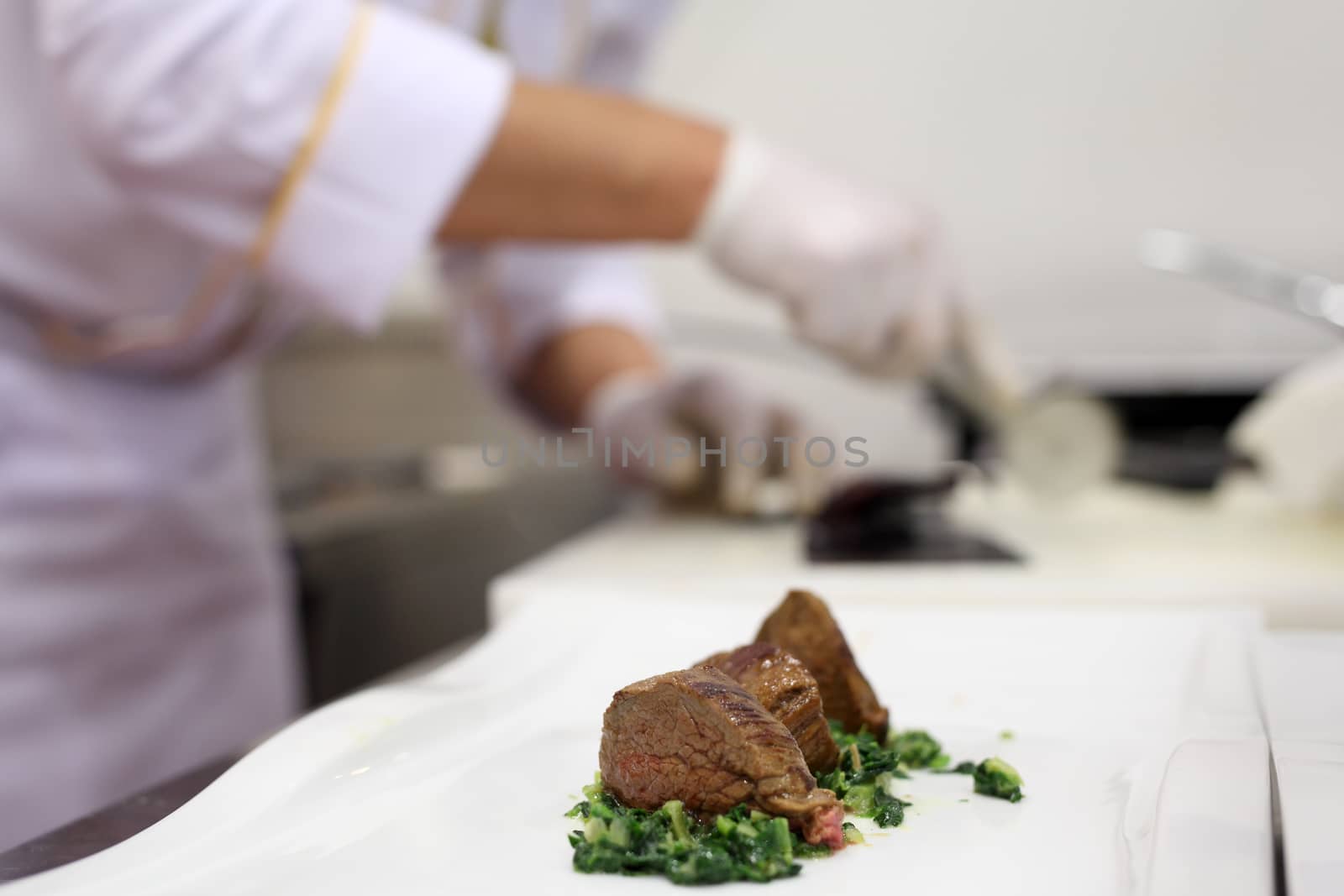 In a restaurant kitchen a chef is preparing tenderloin meat