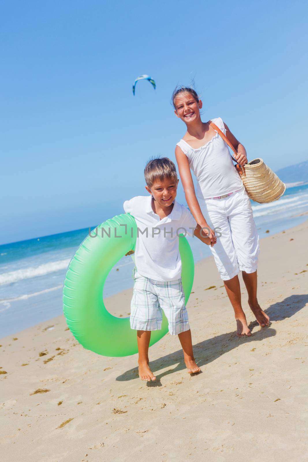 Beautiful brother and sister walk on the beach