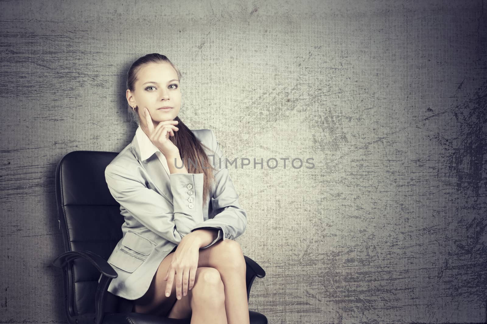 Businesswoman in office chair, looking at camera by cherezoff