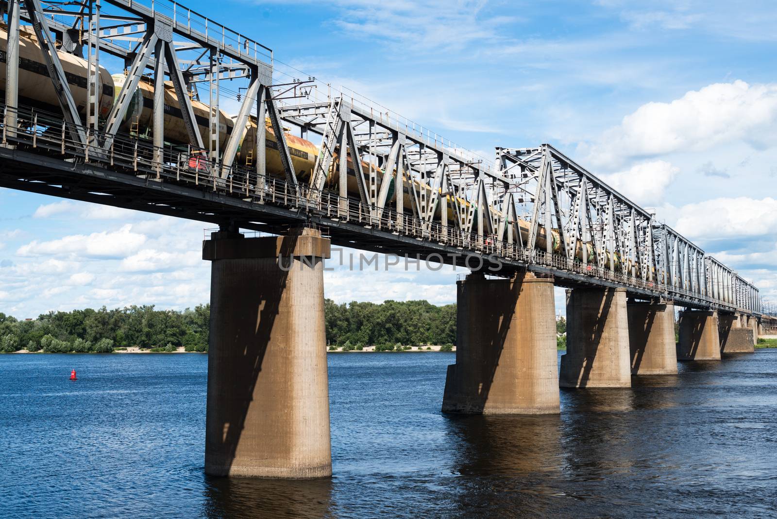 Petrivskiy railroad bridge in Kyiv across the Dnieper with freight train on it.