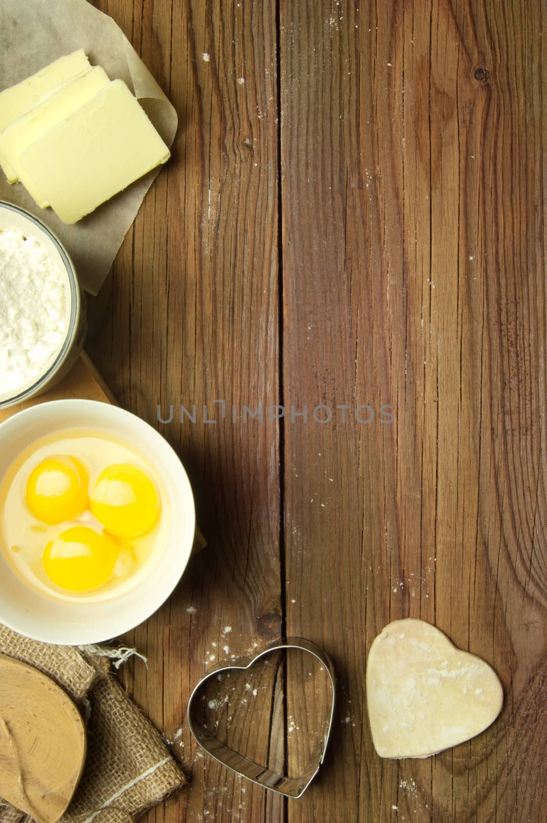 Baking preparation ingredients including eggs, flour and heart shape cookie shapers