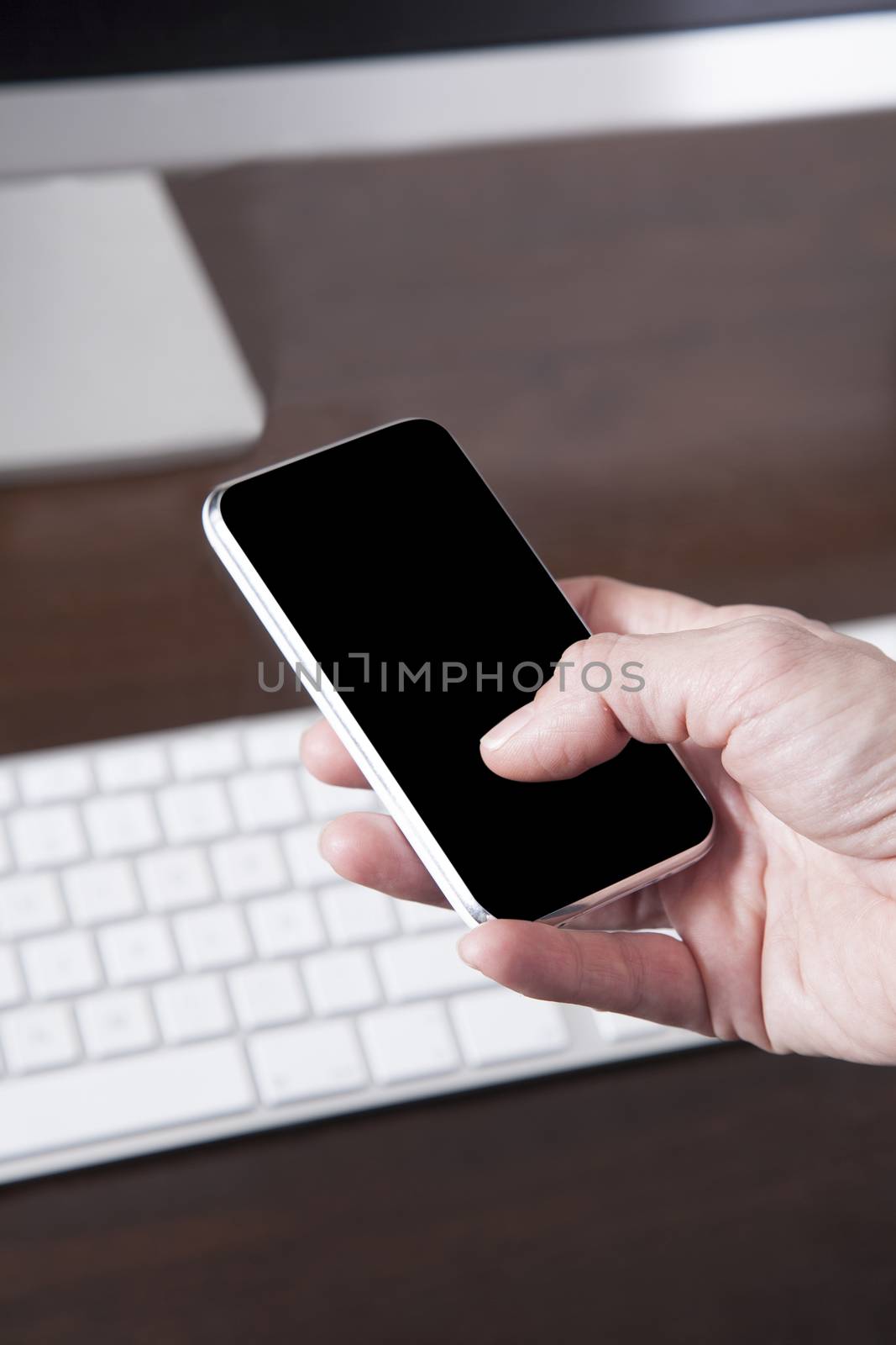 blank black screen smartphone close in woman hands over keyboard computer