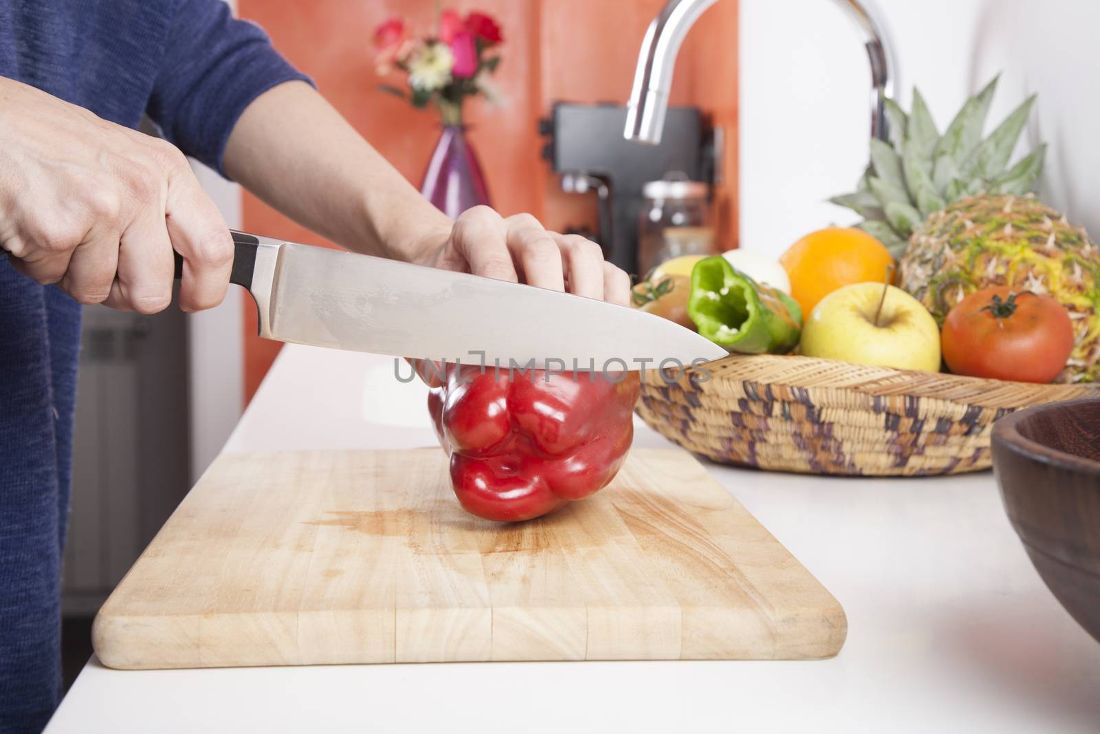 woman hands cutting red fresh pepper slices on brown wood plank white worktop
