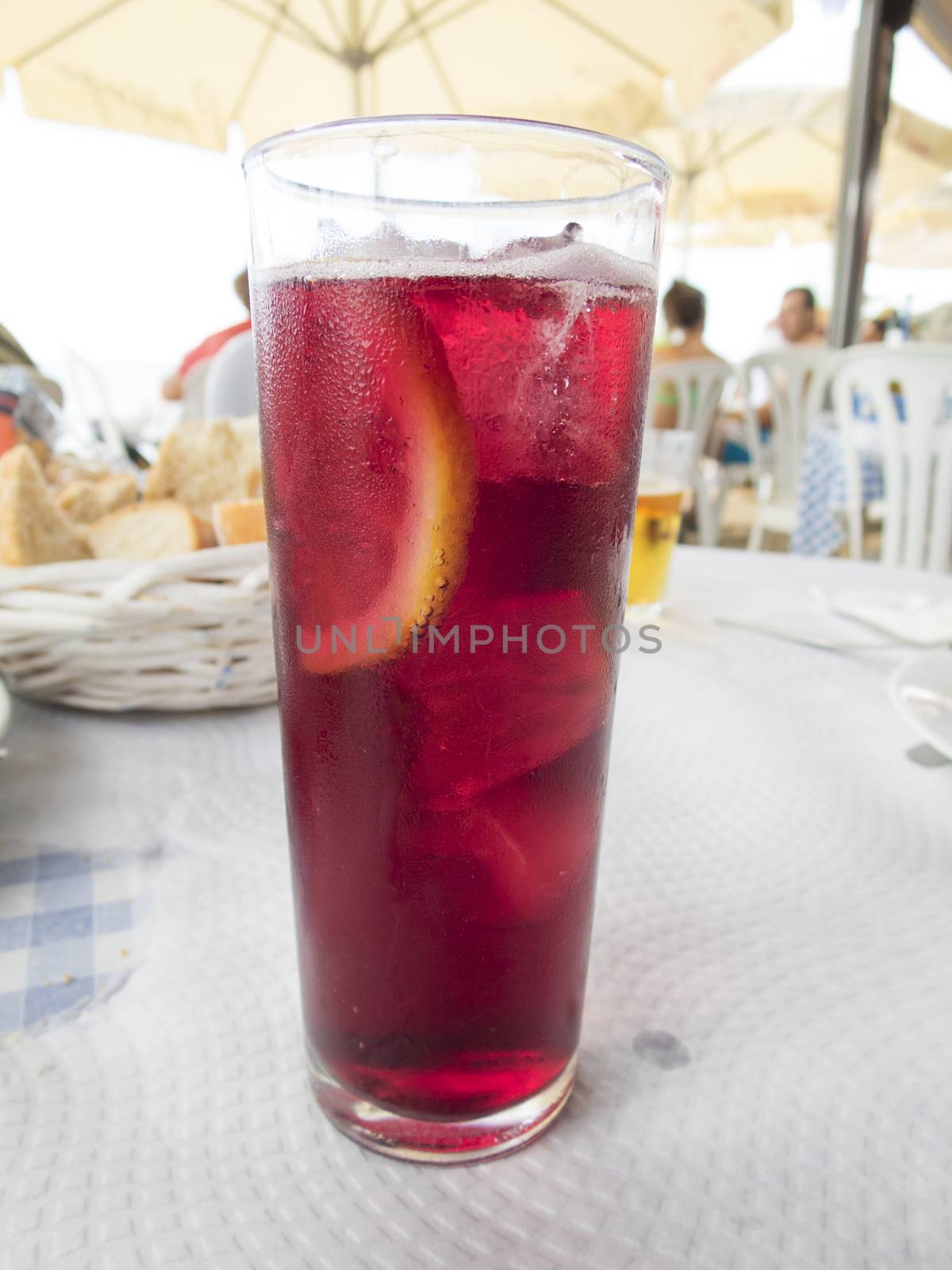 macro of crystal glass full of sangria typical spanish drink with slice lemon on white paper tablecloth restaurant