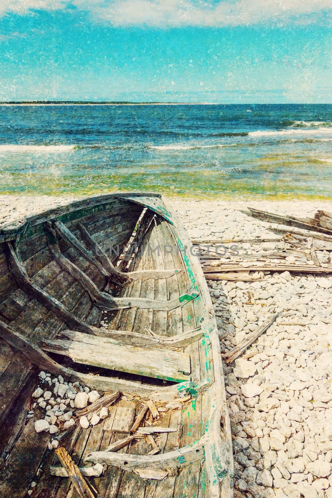 Old wooden boat on the seashore, vintage styled aged photo.