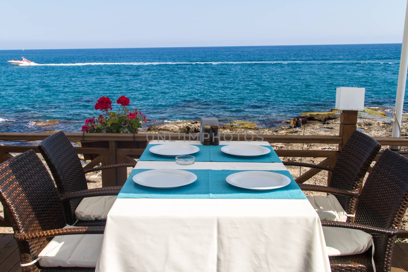 Lunch table at outdoor seaside restaurant by sea.