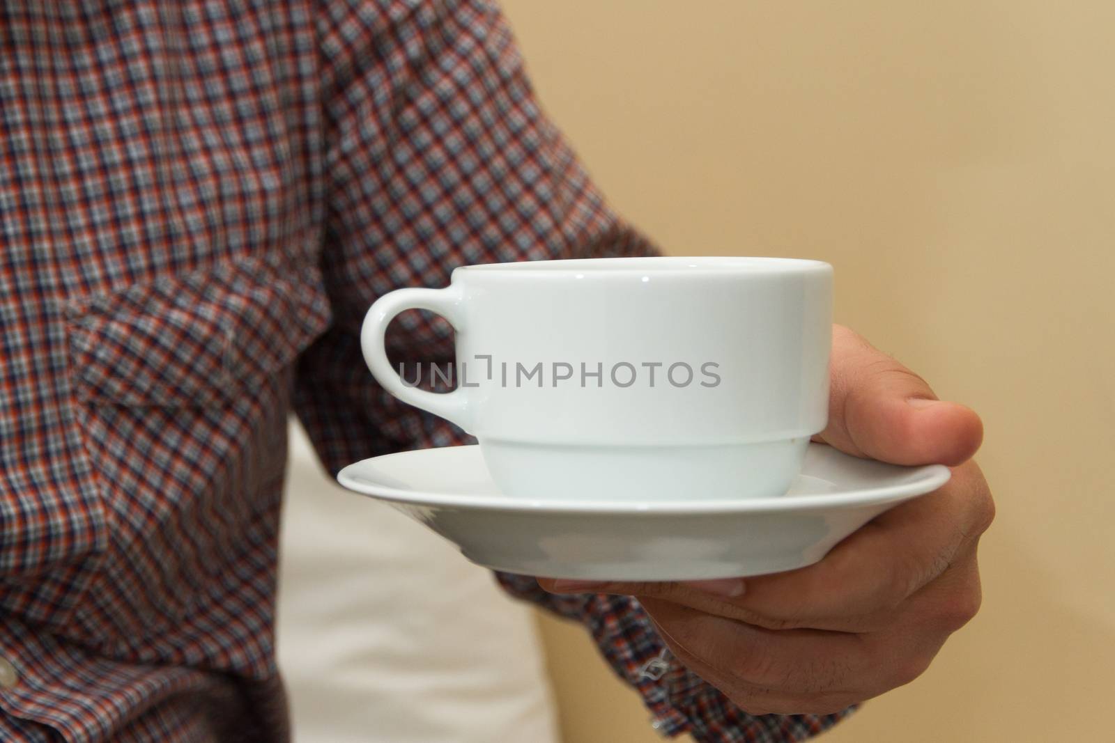 Man holding white cup of coffee with his hand.