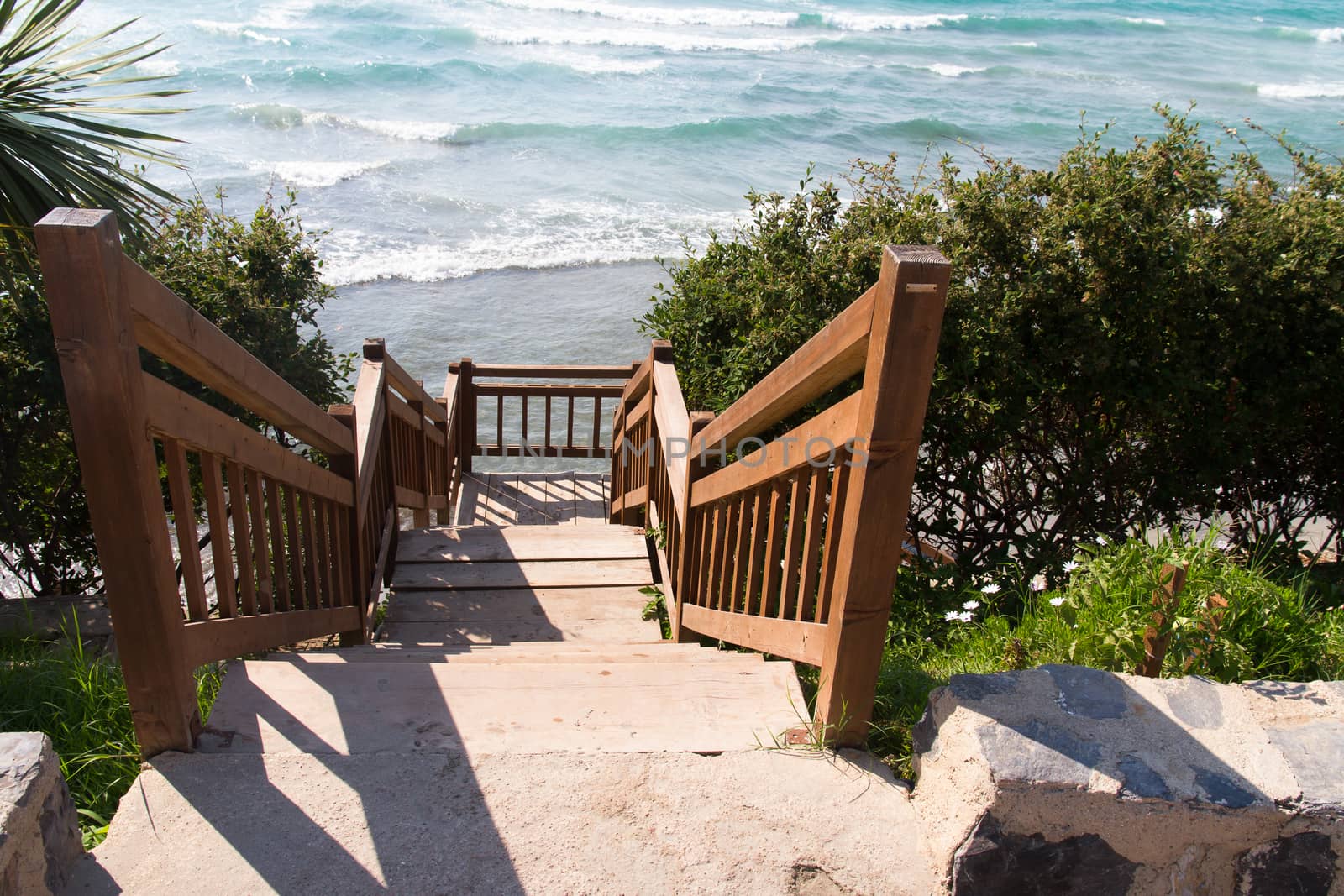Stairs near beach and wavy clean sea.