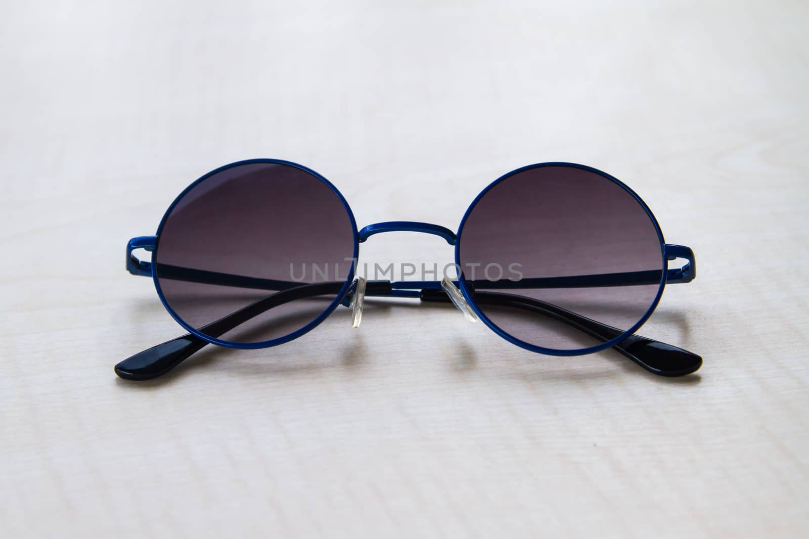 Front view of sun glasses on wooden table.