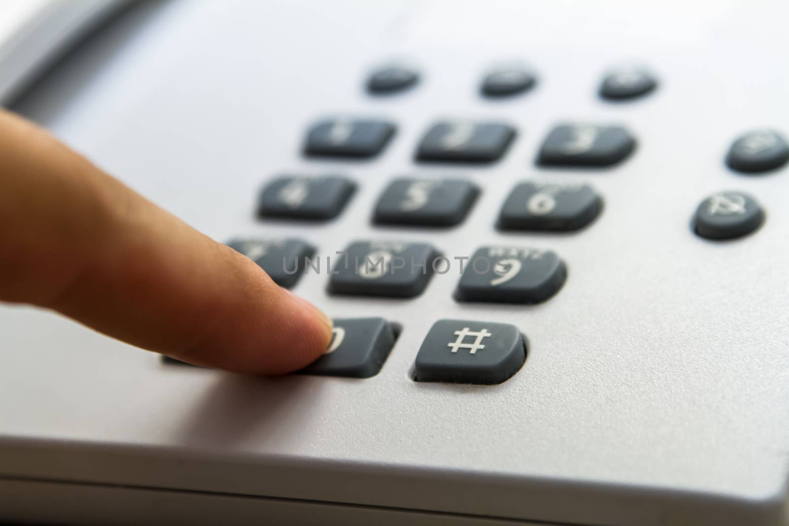 Finger pressing phone key, telephone for customer service in hotel room.