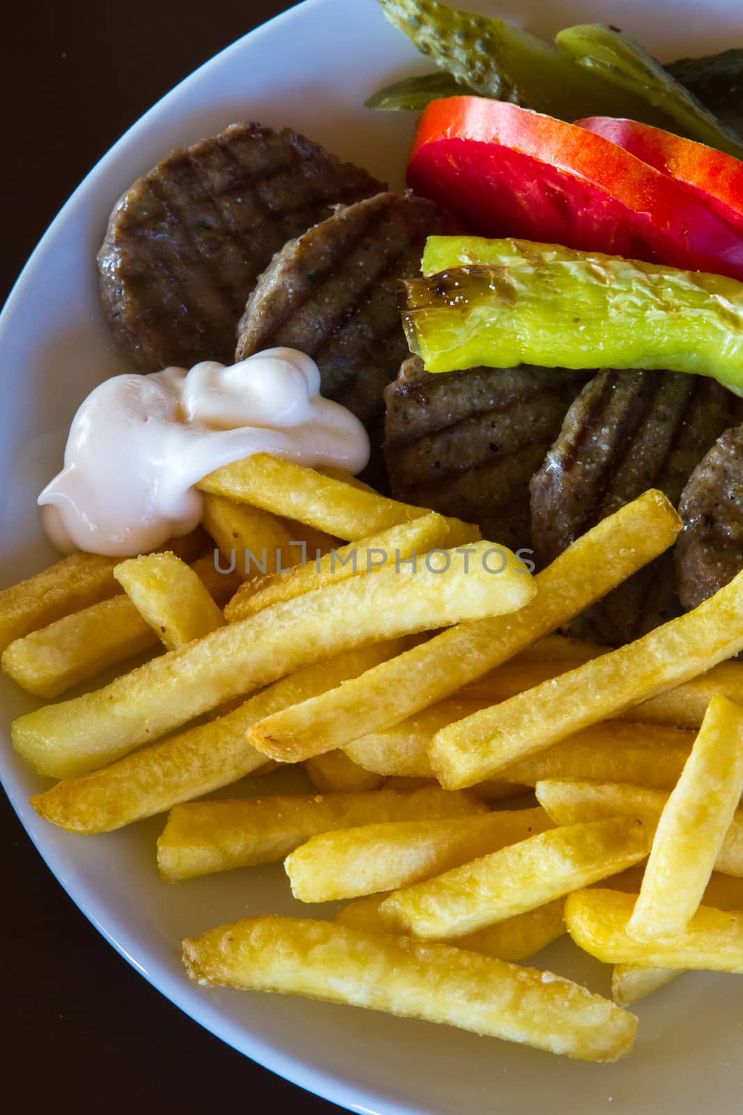 Lunch meal, meatball with sliced potatoes, pepper and tomatoes.