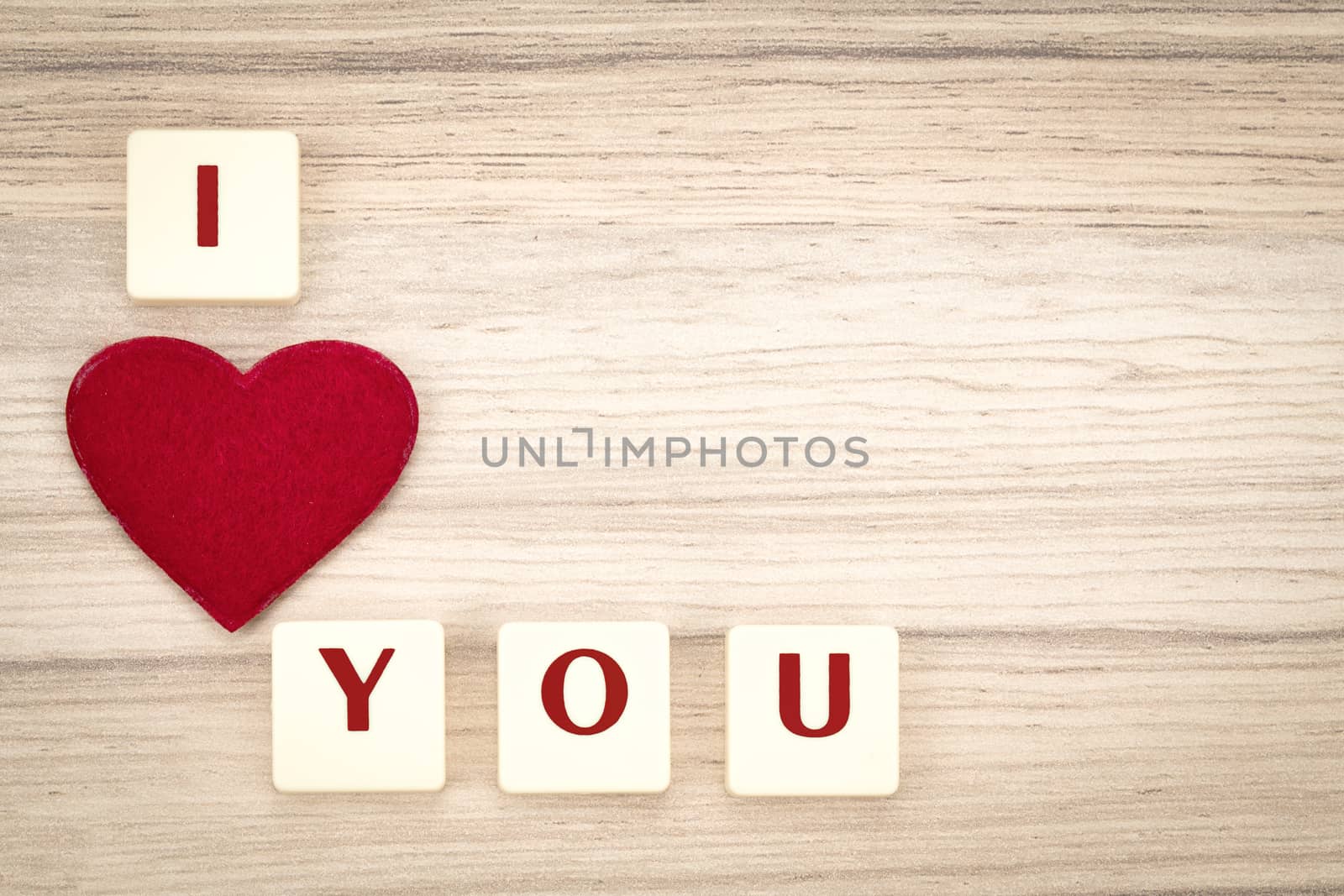 valentine's hearts on a wooden background , valentine's day , day valentine postcard with scrabble text I love you