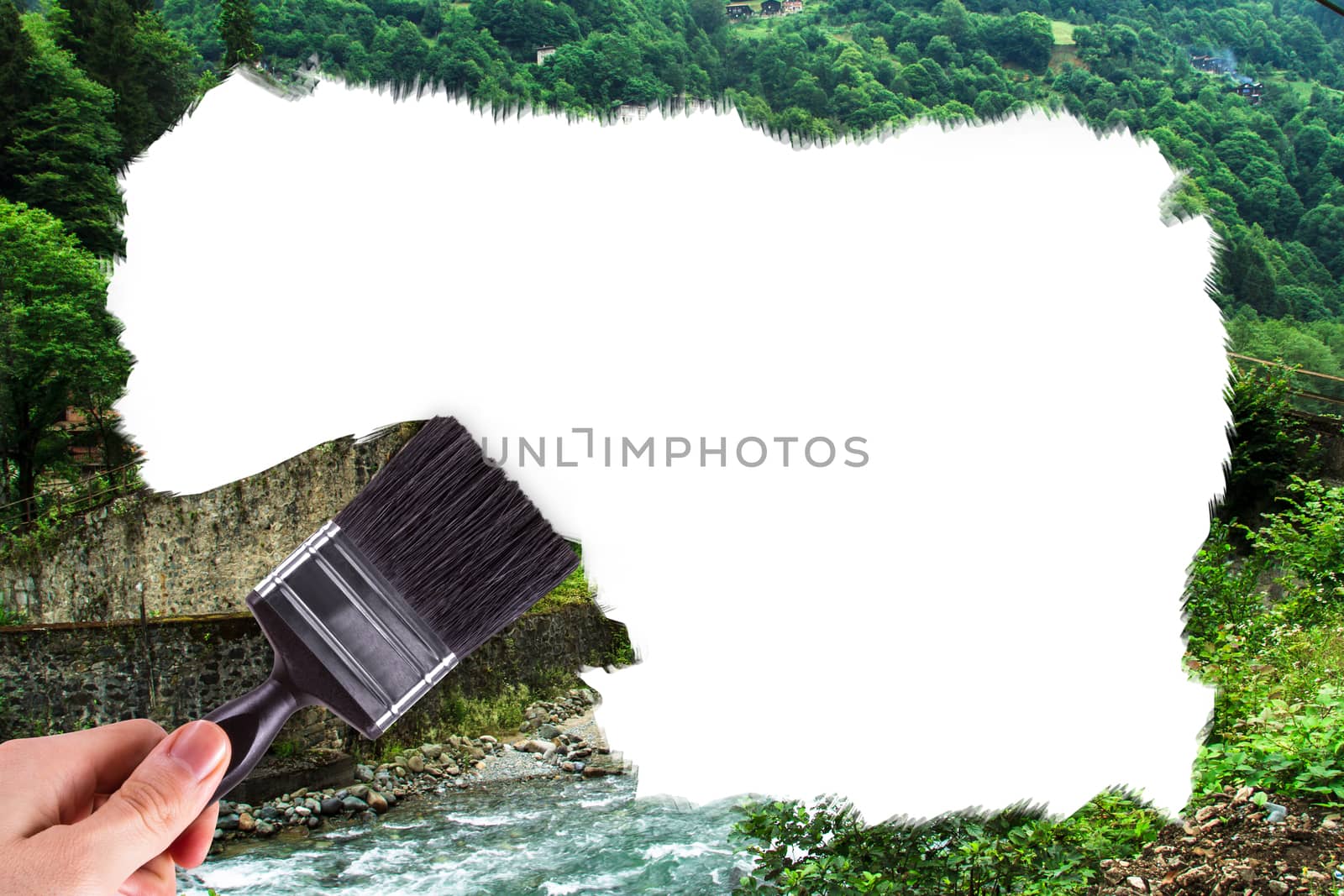 Male hand holding paint brush and painting plateau picture with copy space.