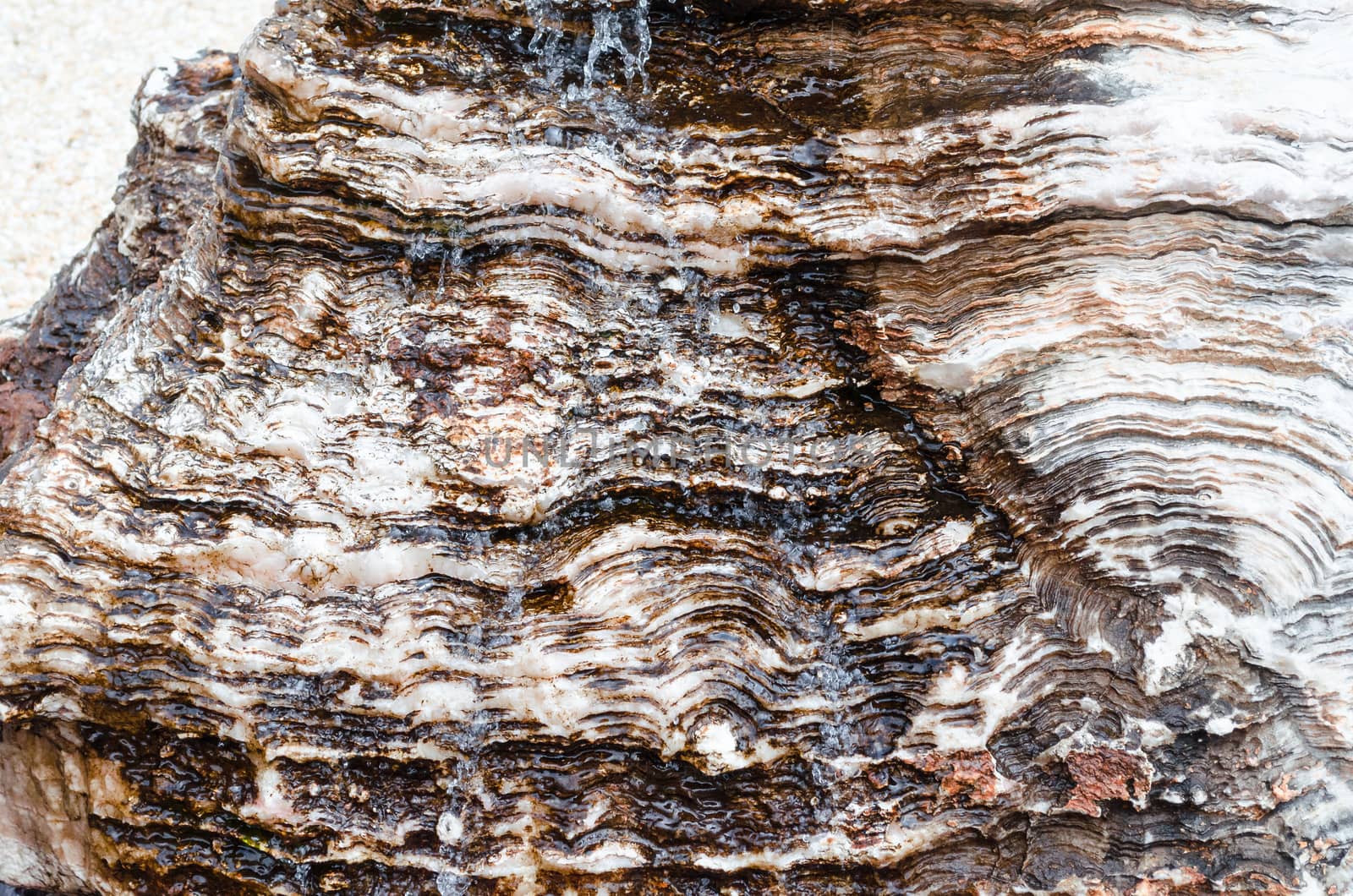 Water flows over a rock or stone.