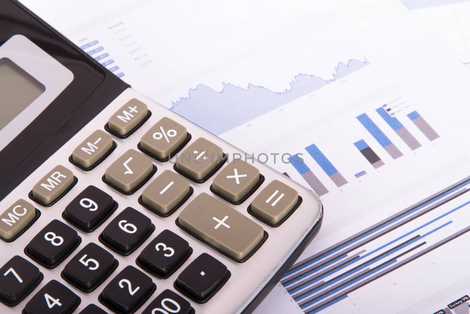 Calculator on financial data graphs.