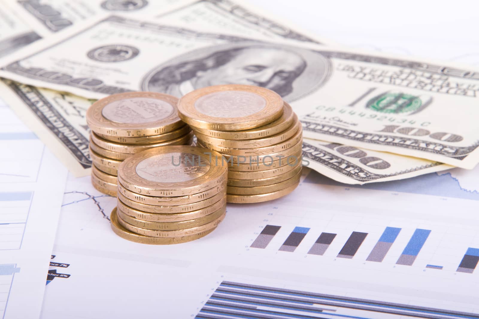 Dollar banknotes and coins on bar chart graphic results.