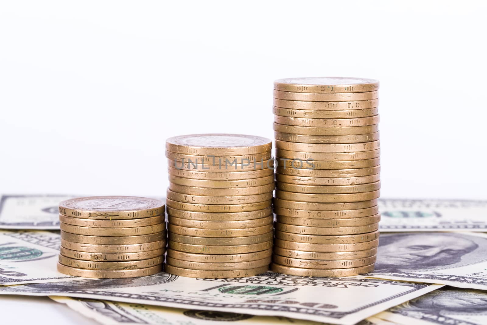 One hundred dollar banknotes and coins, isolated on white background.