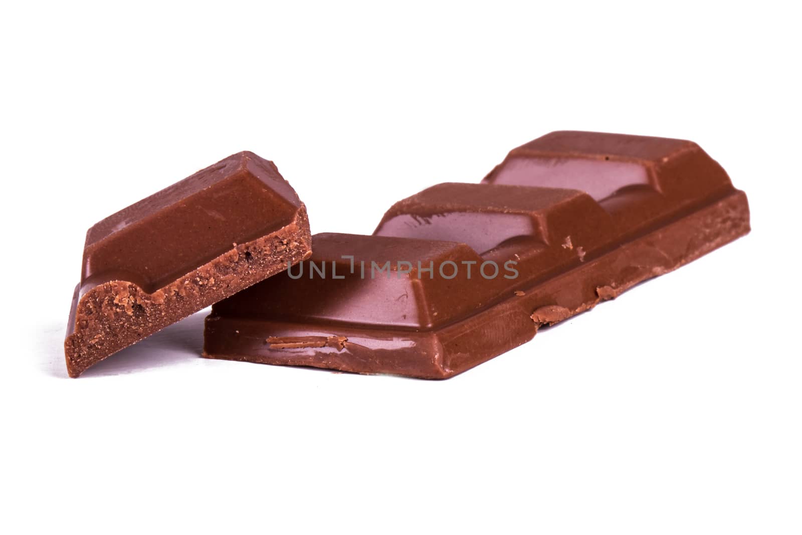 Broken milk chocolate bar pieces, isolated on white background.