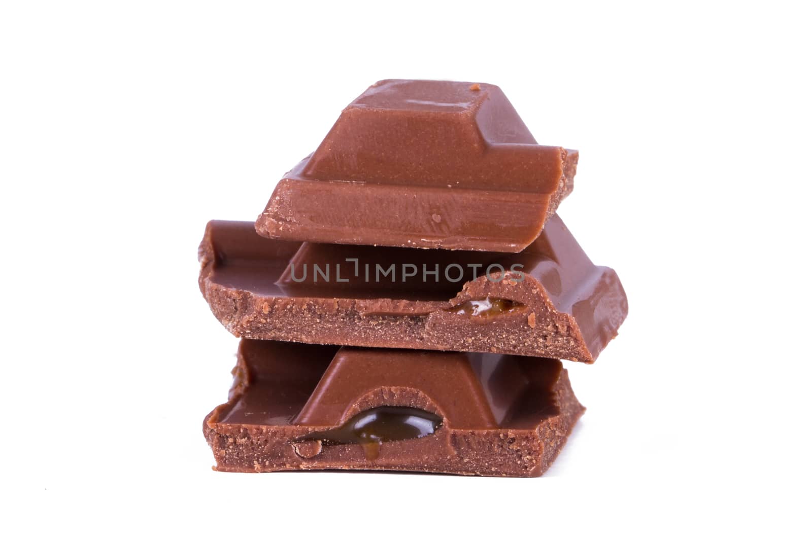 Close up view of chocolate bar pieces, isolated on white background.