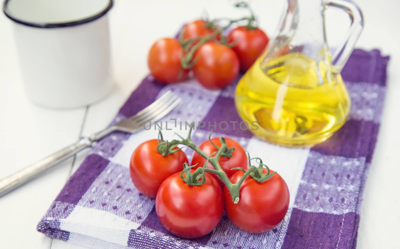  few fresh ripe tomatoes on a branch with olive oil